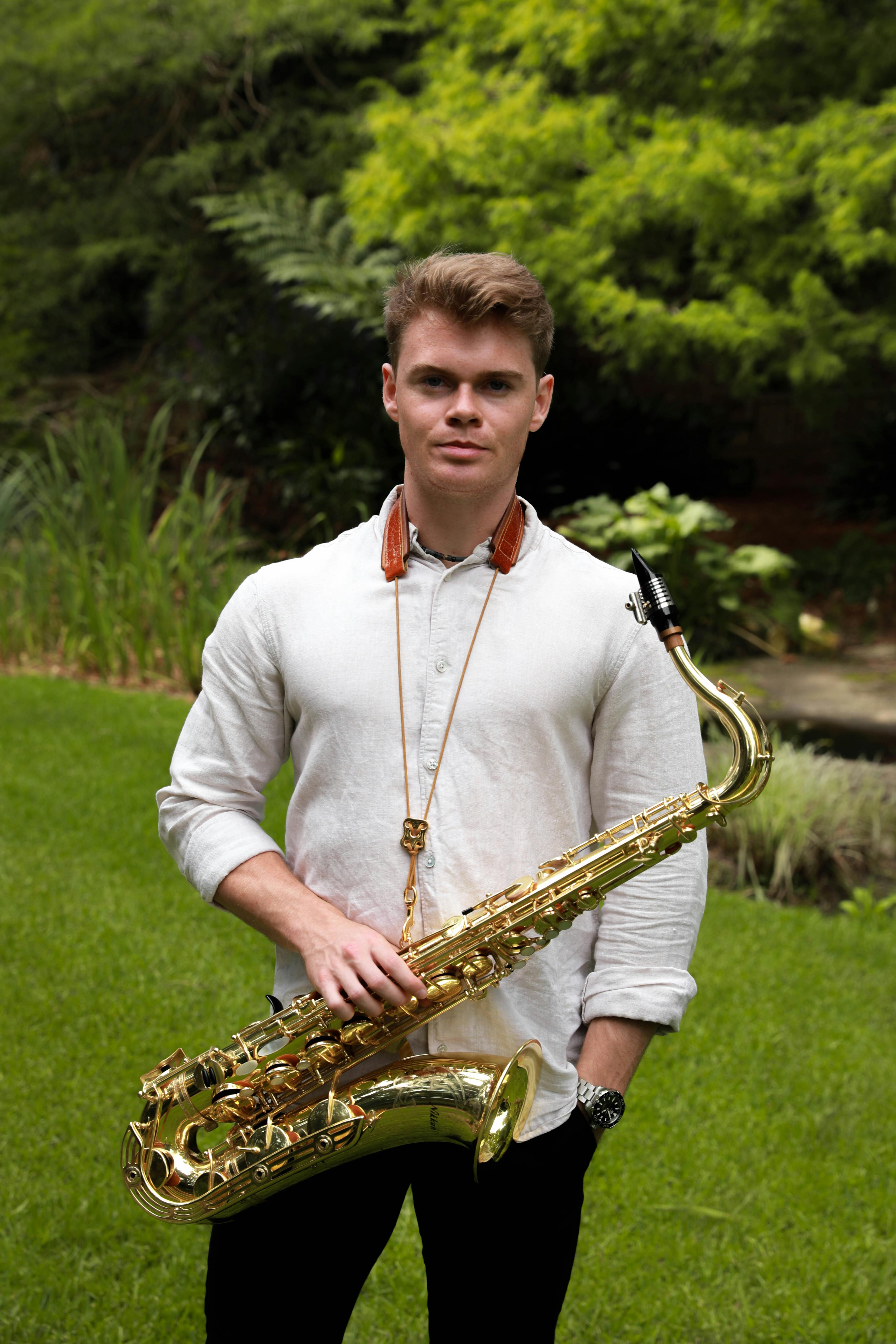 Jayden standing with a saxophone